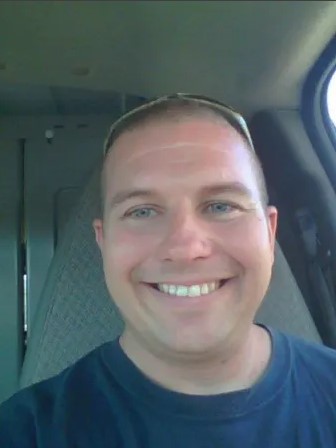 Laron Loe III, owner of Loe's Appliance & AC, in front of a service van